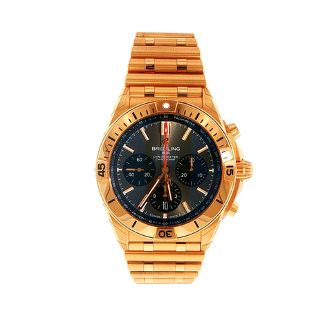 Rose Gold Breitling Chronomat with a black face on a white background