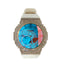 Custom iced out Casio G-Shock GM-2100 watch with diamond bezel, blue glass, and white silicon strap