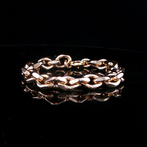 A rose gold chain link bracelet with a polished finish, displayed on a reflective black surface.