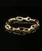 A gold chain link bracelet with a lobster clasp, displayed on a reflective black surface.