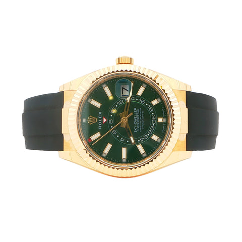 Gold watch with green face and black strap on a white background