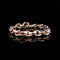A rose gold chain link bracelet with a polished finish, displayed on a reflective black surface.
